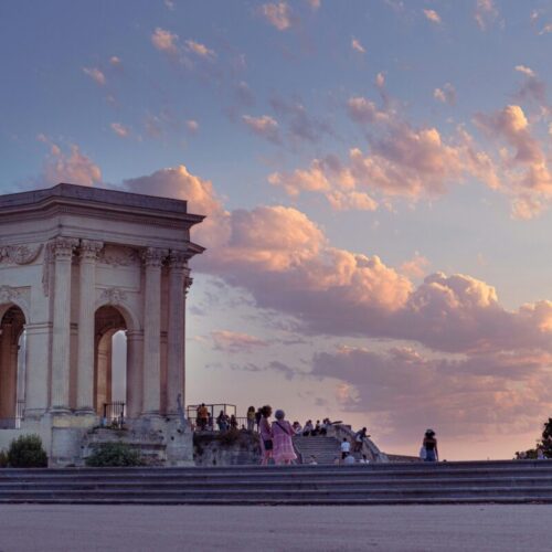 CyberTour: Monument historique au coucher du soleil avec visiteurs.