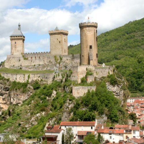 CyberTour: Château sur colline avec tours, maisons en dessous.